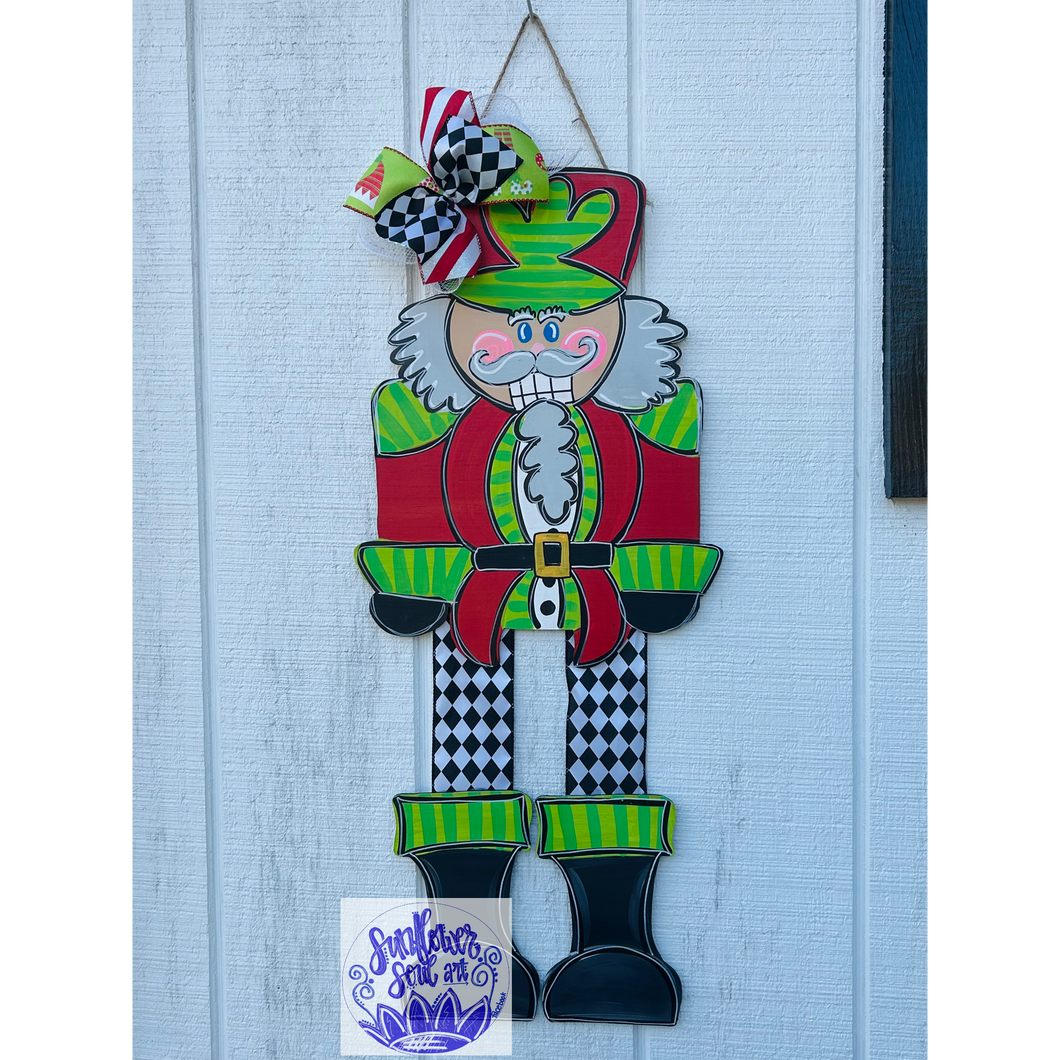 Nutcracker door hanger with ribbon legs, green and red.